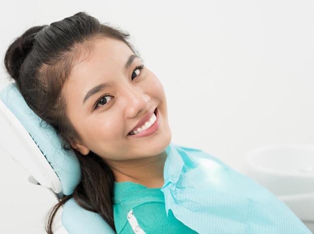 a patient smiling after getting her dental crown
