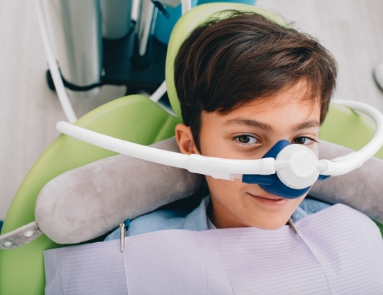 Boy in dental chair wearing nitrous oxide nasal mask