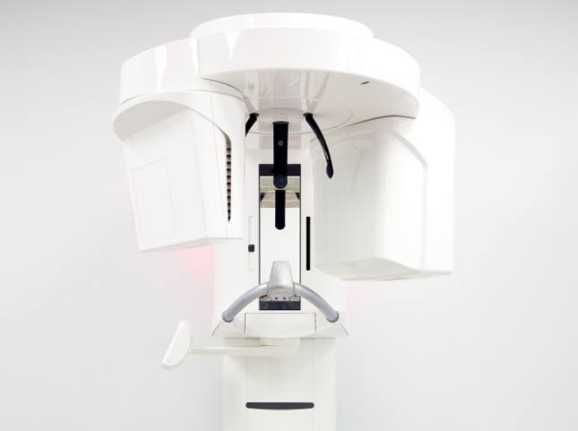 3 D cone beam scanner standing against white wall