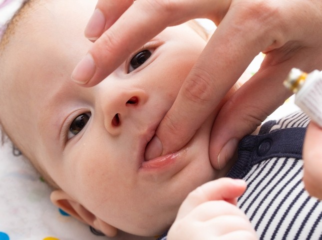 Person examining a babys mouth