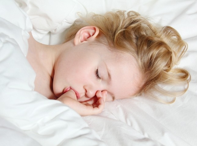 Child sucking their thumb while sleeping
