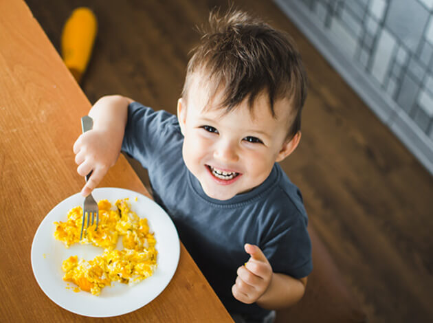 Child eating scrambled eggs after tooth extraction   