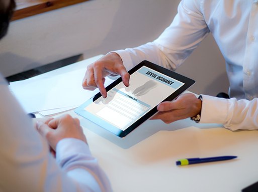 Two people looking at an ipad with “Dental Insurance” listed