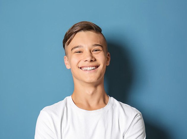 a teen smiling with a bright and comfortable smile