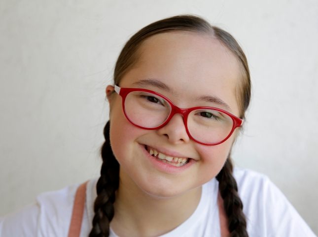 Smiling girl with braids and glasses