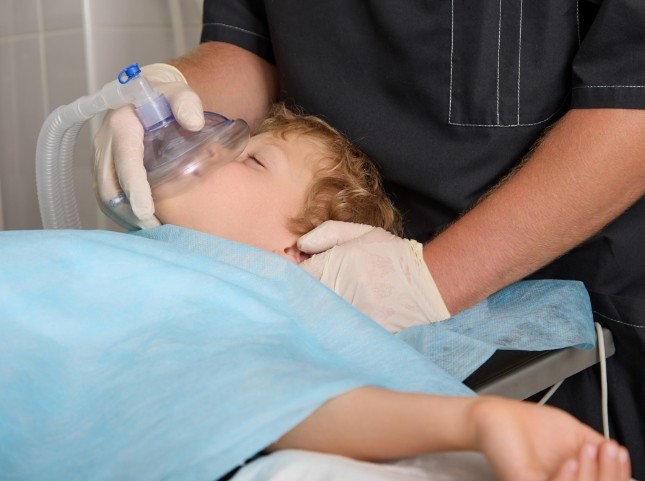 Child in dental chair with nitrous oxide mask over their nose