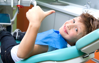 young child smiling while visiting dentist 